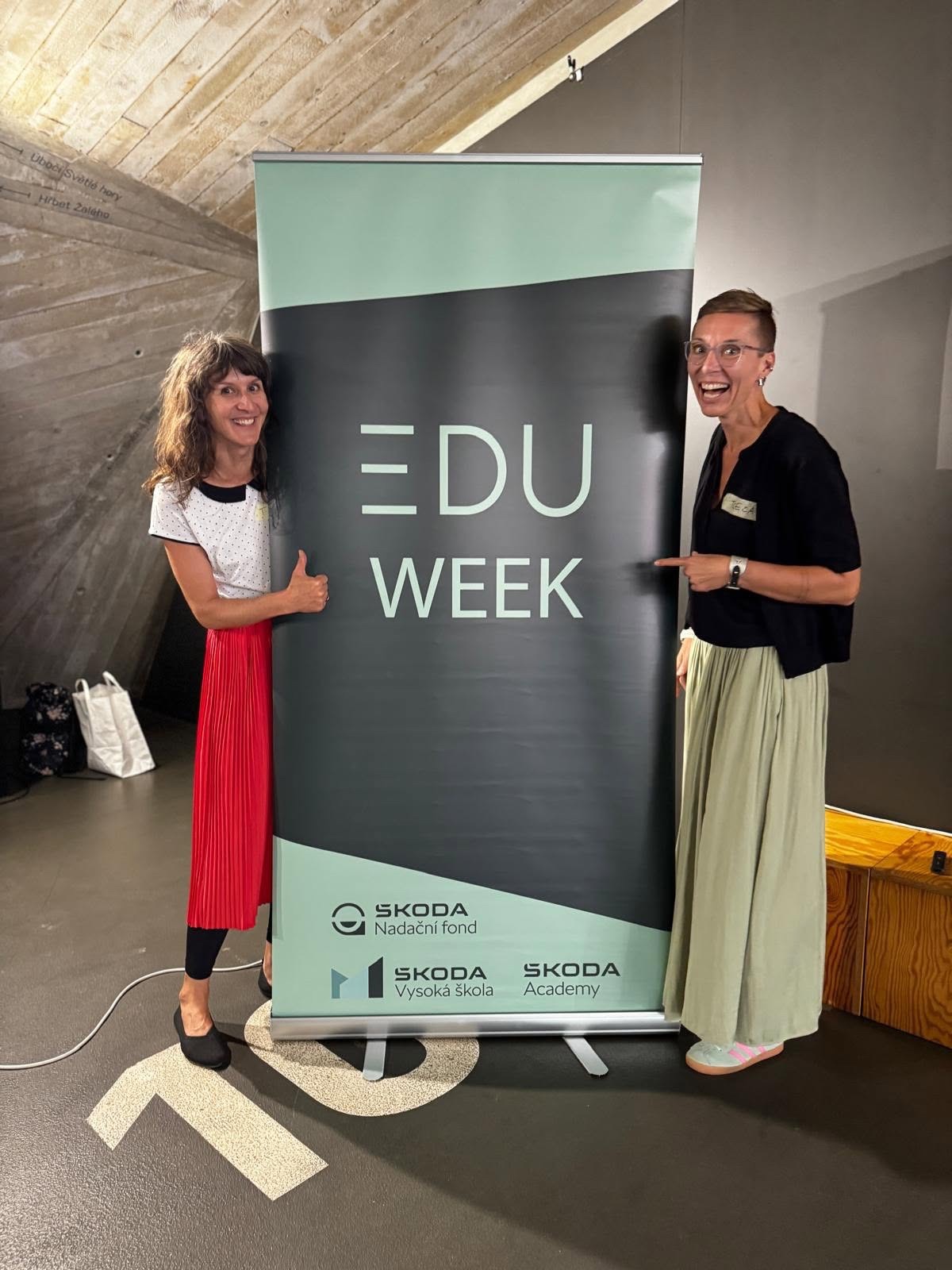Dvě účastnice setkání u banneru EDU Week.